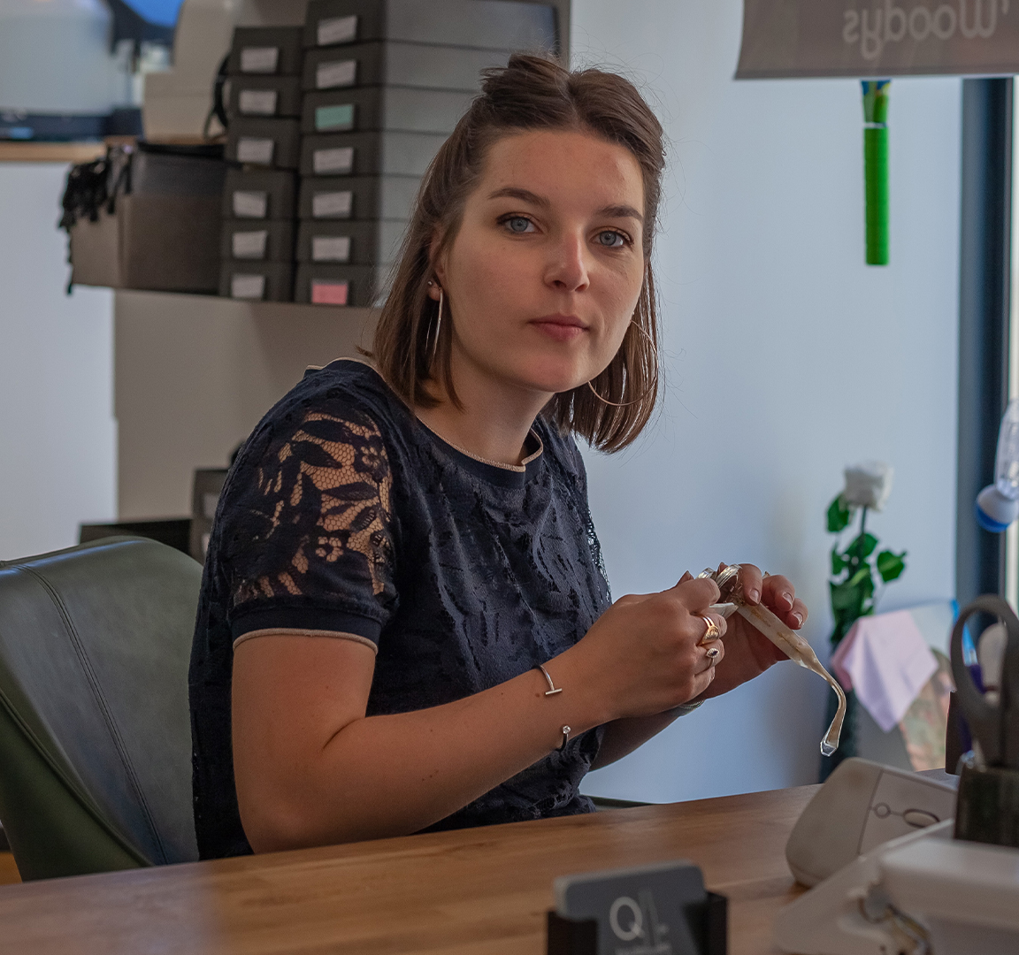 Portrait de Marie BERNARD, opticienne à Aurec-sur-Loire, dans sa boutique, illustrant son engagement envers une expérience optique personnalisée et de qualité.